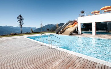 Outdoor Pool mit großer Rutsche im Family Home Alpenhof.