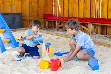 Zwei Jungs spiele auf dem Outdoor Spielplatz vom Family Club Harz im Sandkasten
