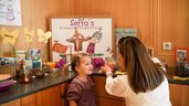 Kind freut sich am bunt gestalteten Kinderfrühstücksbuffet im Familienhotel Sonne Bezau.
