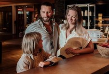 Familie beim herzlichen Check In an der Rezeption des Familienhotel Mia Alpina in Tirol.
