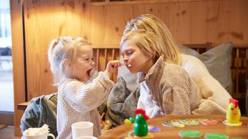 Mutter mit ihren beiden Kindern beim Kuchenessen im Familienhotel Das Bayrischzell