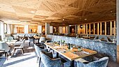 Restaurant mit großen Tischen und gemütlichen Sesseln im modernen Stil im Familienhotel Das Bayrischzell in Oberbayern.