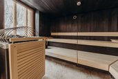 Moderne finnische Sauna mit Holzbänken und Blick auf die Landschaft im Familienhotel Habachklause.