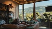Raum für Wellnessbehandlungen im Familienhotel Mia Alpina in Tirol mit Behandlungsliegen, großen Fenstern und Bergblick.