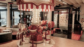 Historisches Karussell in der Indoor-Spielwelt des Familienhotel Mia Alpina in Tirol.