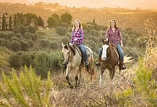Ausreiten mit Pferden bei Sonnenuntergang im Familienhotel Castellare di Tonda in der Toskana