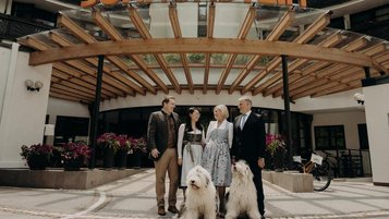 Die Familie Zitka steht mit ihren beiden Hunden vor dem Hoteleingang des Hotel Sonngastein im Salzburger Land.