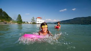 Mädchen planscht fröhlich im See.