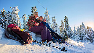 Eine Gruppe Winterwanderer macht eine Pause in der Nähe von Sankt Englmar im Bayerischen Wald im Schnee.
