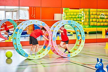 Kinder spielen in der Indoor-Spielhalle im Familienhotel Aigo welcome family in Oberösterreich.