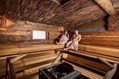 Paar entspannt in der gemütlichen Holzsauna im Familienhotel Feldberger Hof im Schwarzwald.